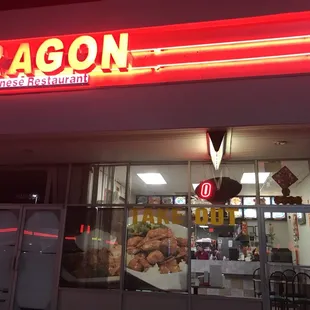 the front of a restaurant with a neon sign