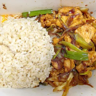 rice, chicken, and asparagus in a styrofoam container