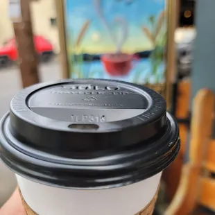 a hand holding a coffee cup