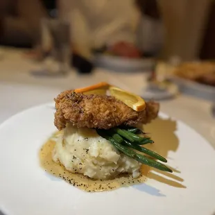 a plate of food with mashed potatoes and green beans