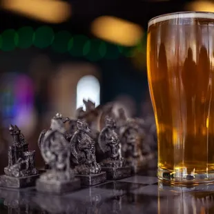 a glass of beer and chess pieces
