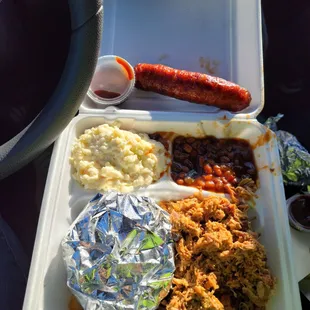 Pulled pork sandwich, cole slaw, baked beans and smoked sausage.