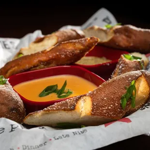 a basket of pretzels with dipping sauce