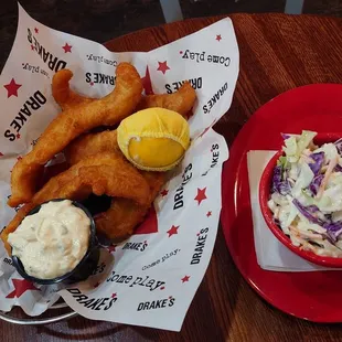 Beer battered white fish with tartare sauce and coleslaw side.