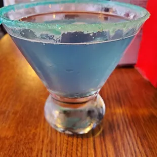 a blue drink in a martini glass