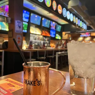 a copper mug with a straw and a glass of ice