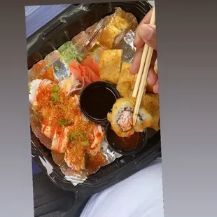 a tray of sushi with chopsticks