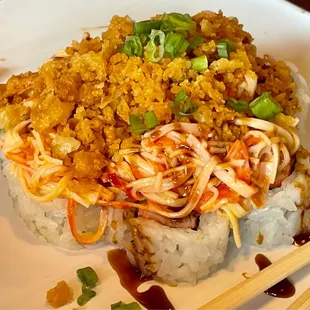 a plate of sushi with chopsticks