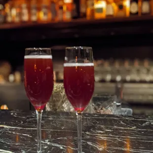 two glasses of wine on a bar