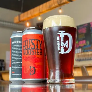 a glass of beer next to a can of beer