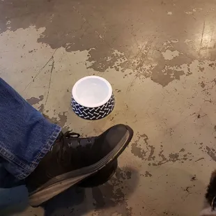 a cup of coffee and a person&apos;s feet