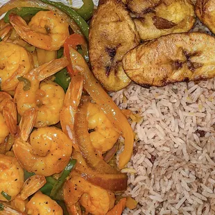 Curried shrimp served with rice and peas and a side of fried plantain.