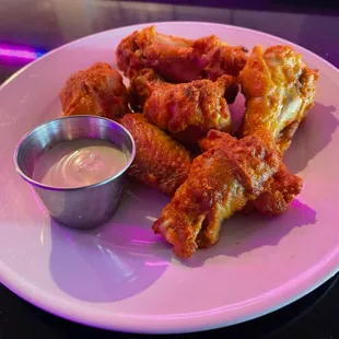 a plate of chicken wings with dipping sauce