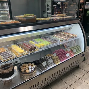 Front dessert and cake display full of cakes and mini cannoli eclair cream burlee