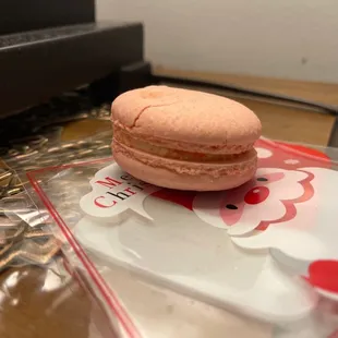 a pink macaron on a hello kitty plate