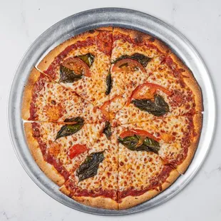 Pizza with marinara sauce, fresh garlic, mozzarella cheese, fresh basil, tomato, and a drizzle of olive oil.