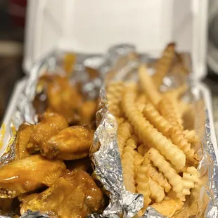 a tray of chicken wings and french fries
