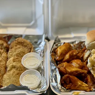two trays of chicken wings and fries