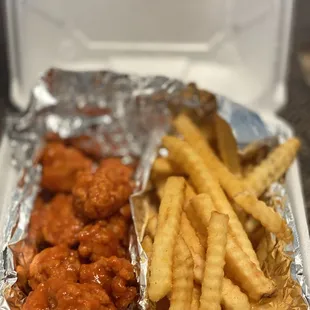 a tray of chicken wings and french fries