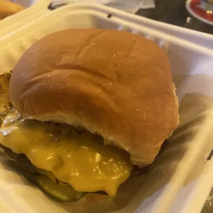 cheeseburger and fries in a styrofoam container