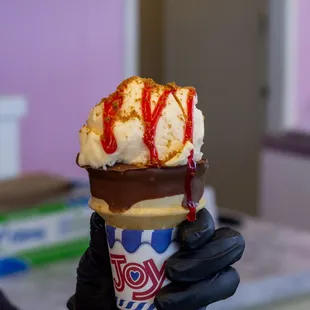 a hand holding an ice cream cone