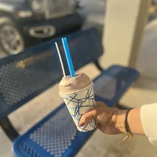 a hand holding a cup of coffee