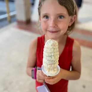 a young girl holding a cone of ice cream