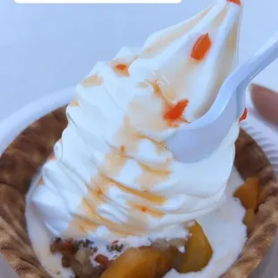 Peach cobbler in a waffle bowl with ice cream for national ice cream day!