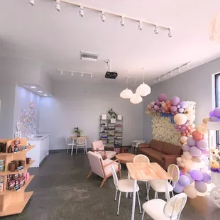 a living room with a sofa, chairs, tables, and balloons