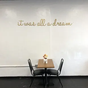 a table and chairs with a vase of flowers on it