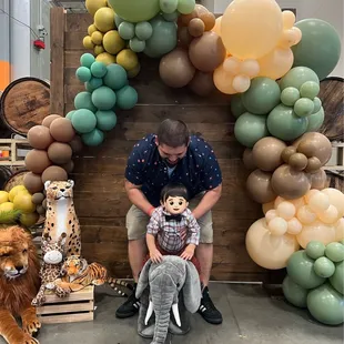 Beautiful safari themed balloon arch W/ wood panel backdrop.