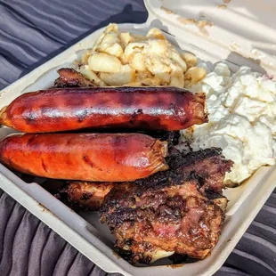 Pork ribs hot off the grill with links. Side of potato salad and mac and cheese.