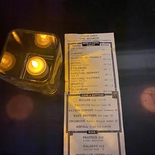a menu and a lit candle