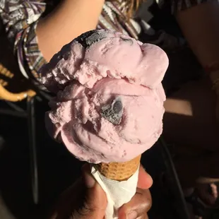 a person holding a cone of ice cream