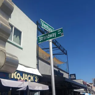 a woman standing under a street sign