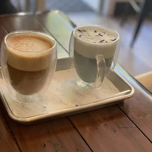 two cups of coffee on a tray