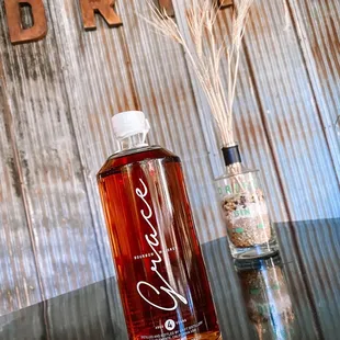 a bottle of whiskey next to a reed