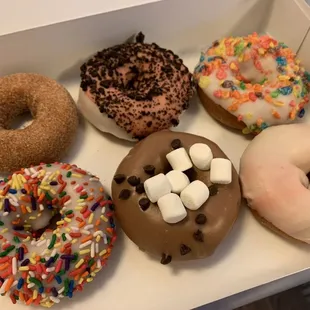 six different flavored donuts in a box