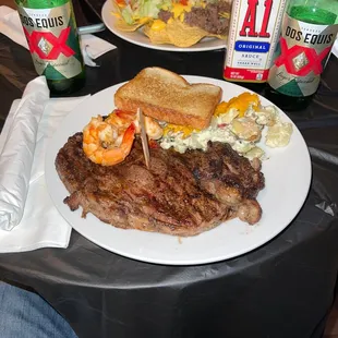 a plate of steak, bread, and salad