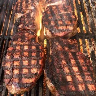 steaks cooking on a grill