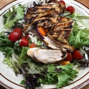 a plate of salad with grilled chicken