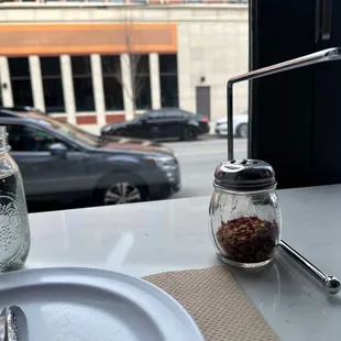 a table with a plate, spoon, and salt shaker
