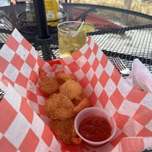 a basket of deep fried shrimp with a side of ketchup