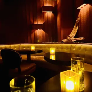 a curved booth with candles