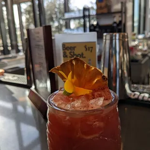a glass of bloody drink with a pineapple garnish
