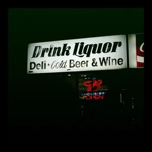 a neon sign for a deli - cold beer and wine shop
