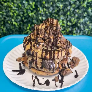 a chocolate covered donut on a paper plate
