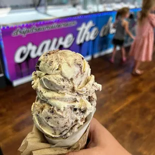 a hand holding a cone of ice cream