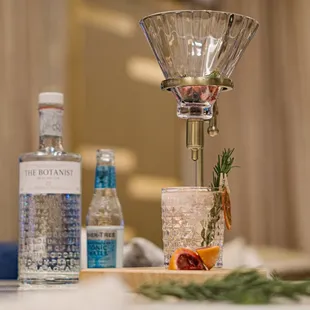 a martini glass with a sprig of rosemary