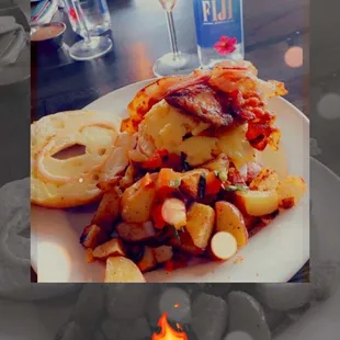 Bagel sandwich with sausage, bacon, eggs, cheese and a side of home fries